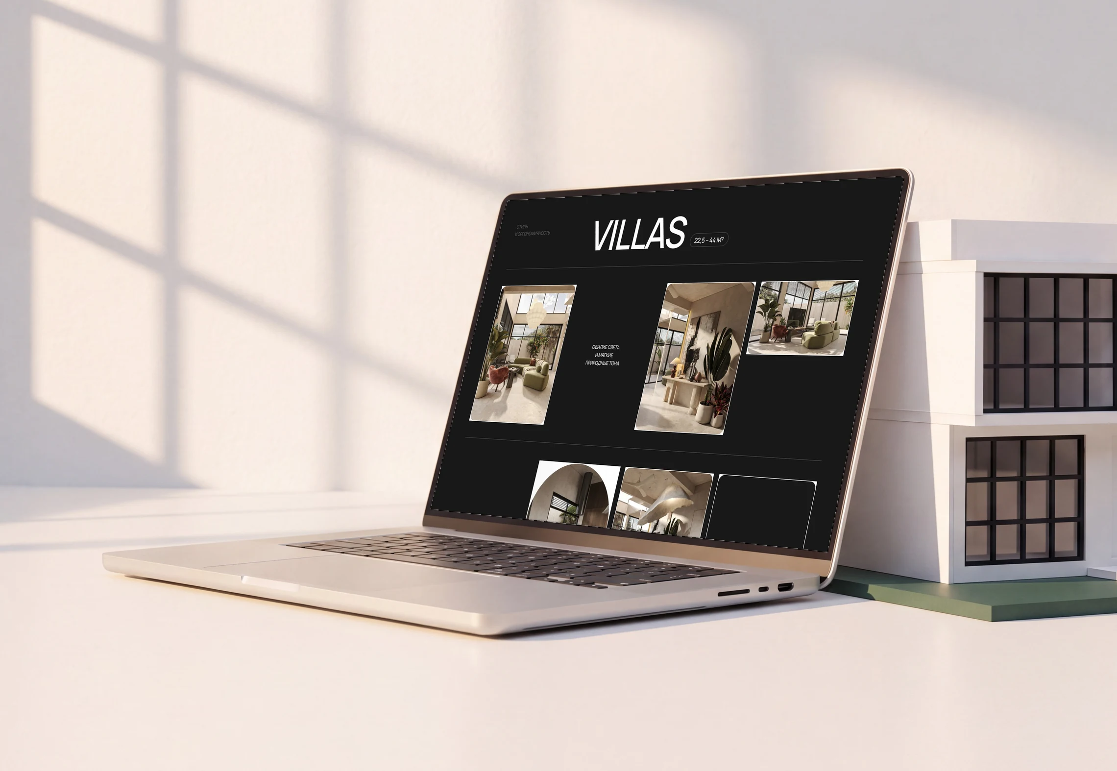The Elysium villa gallery on a laptop beside an architectural model against a light background